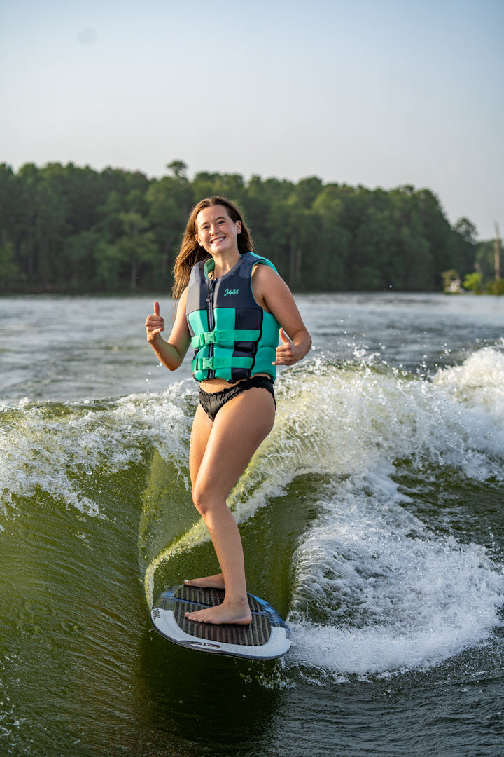 Person wakeboarding on a lake with trees in the background #color_teal