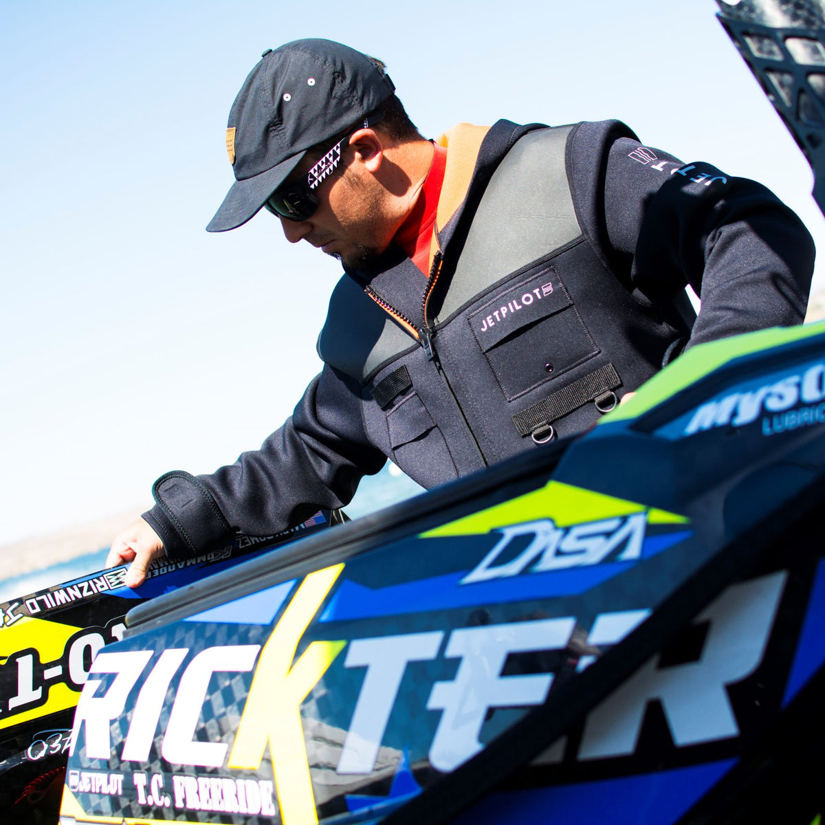Image of a man wearing the Jetpilot Tour Coat working on a jet ski.