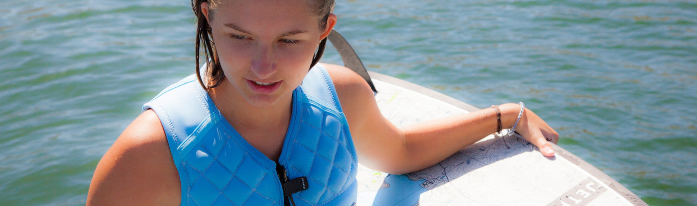 Image of a wakeboarding putting on the Wave Farer Comp Vest