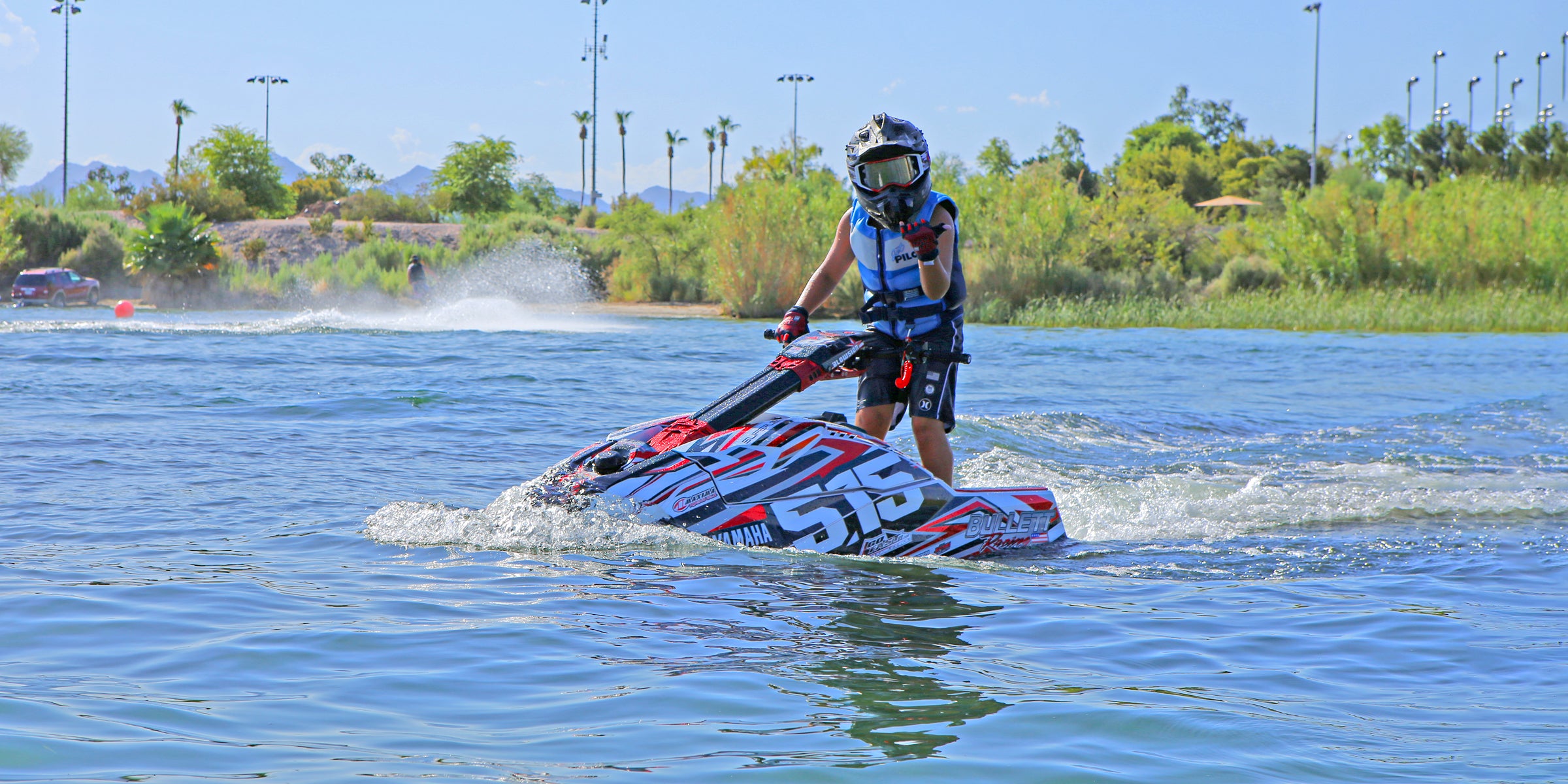 A young rider on the jet ski wearing our Youth Vintage Class Neoprene CGA Vest in the color Blue/White.