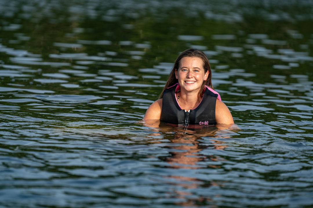 Woman wearing a life jacket in a body of water #color_pink