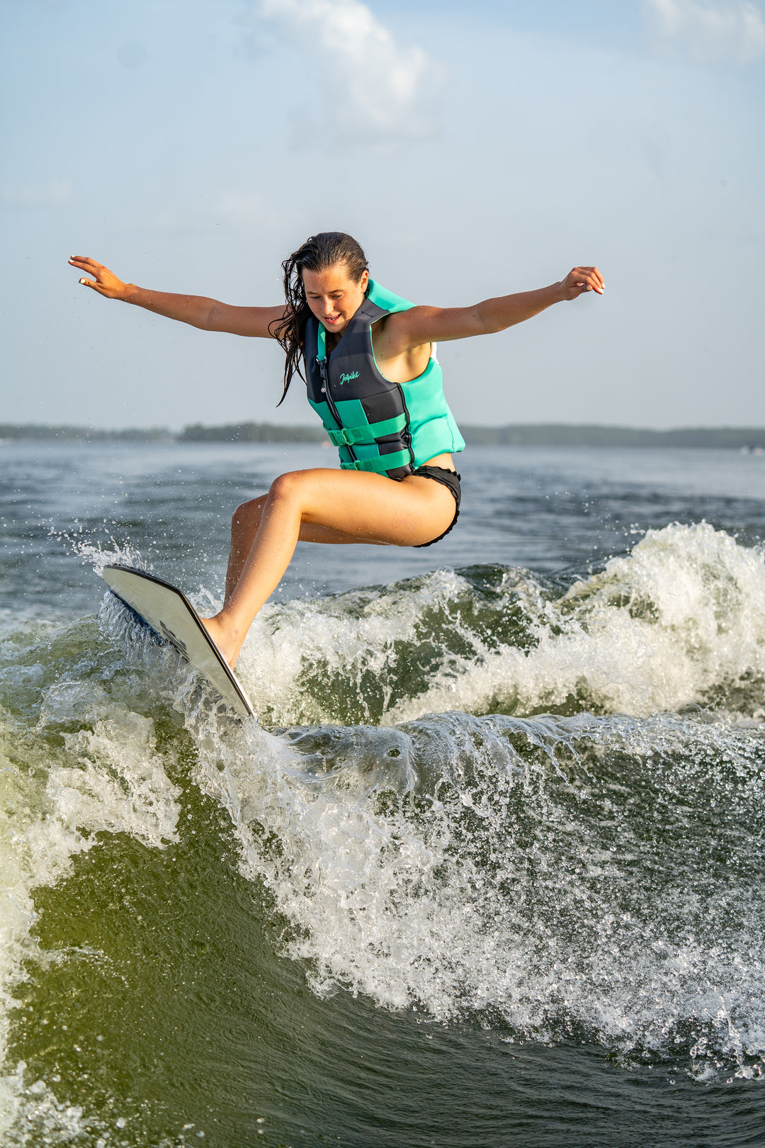 Person wakeboarding on a wave with a clear sky background #color_teal