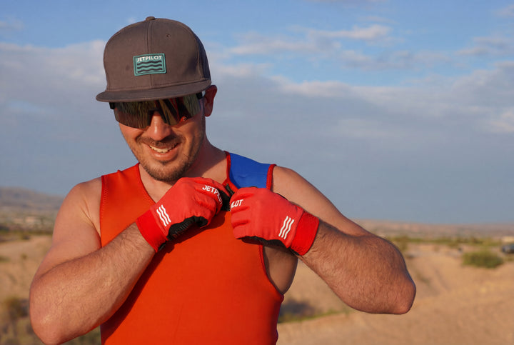 Man in desert wearing red gloves and a cap with sunglasses #color_red