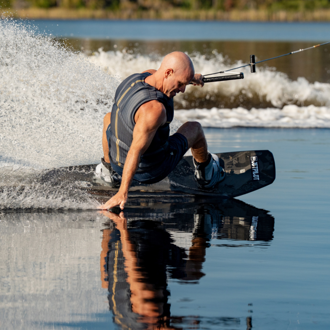 Man wakeboarding on a lake with water splashing around him. #color_gray