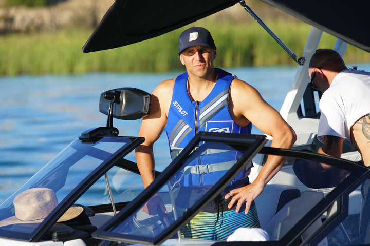 Man wearing the Jetpilot Cause life vest in a wakeboarding boat.