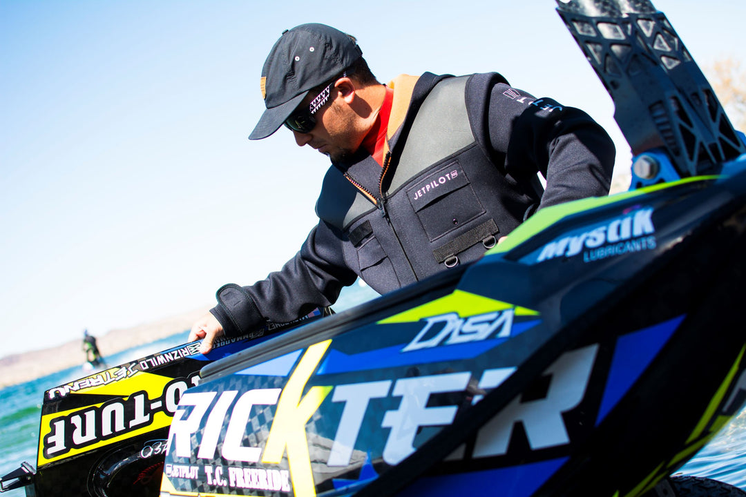 Image of a man wearing the Jetpilot Tour Coat working on a jet ski.