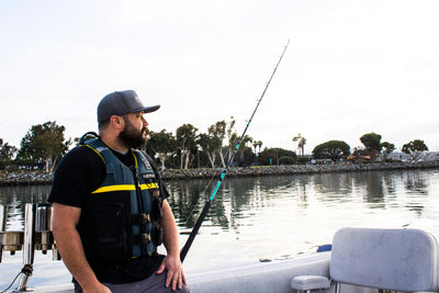 Image of a man wearing the L.R.E. Helmsman life vest while fishing.